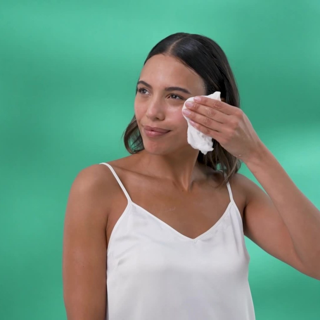 Woman gently removing cleanser from her cheek with a soft cloth during a TEMPLESPA skin gritting ritual.