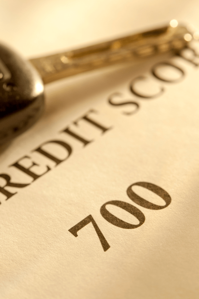 Photograph of a car key lying across an official document that displays a credit score of 700.